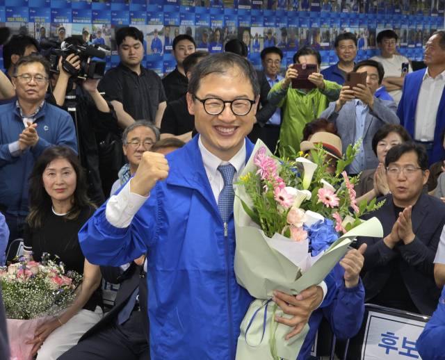 3일 더불어민주당 김상욱 당선인이 선거사무소에서 꽃다발을 든 채 주먹을 불끈 쥐며 지지자들의 환호에 화답하고 있다. 오상민 기자 sm5@