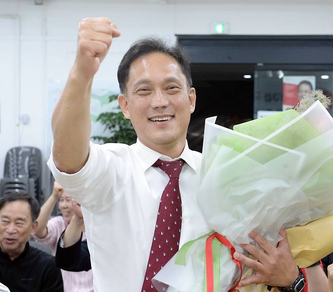 국민의힘 김태규 울산 남구갑 국회의원 후보가 4일 자신의 선거사무소에서 당선이 확실시되자 꽃다발을 받고 환호하고 있다. [사진 연합뉴스]