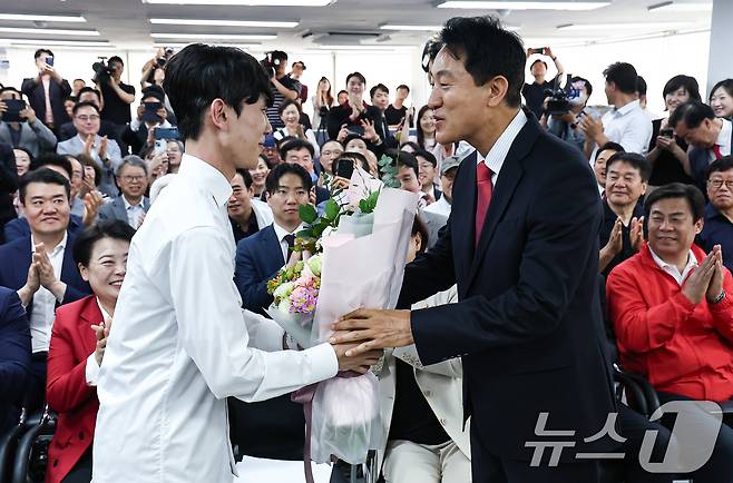 6·3 지방선거에서 당선된 오세훈 국민의힘 서울시장 후보가 4일 서울 종로구 선거사무소에서 꽃다발을 전달 받고 있다. 2026.6.4 ⓒ 뉴스1 김도우 기자