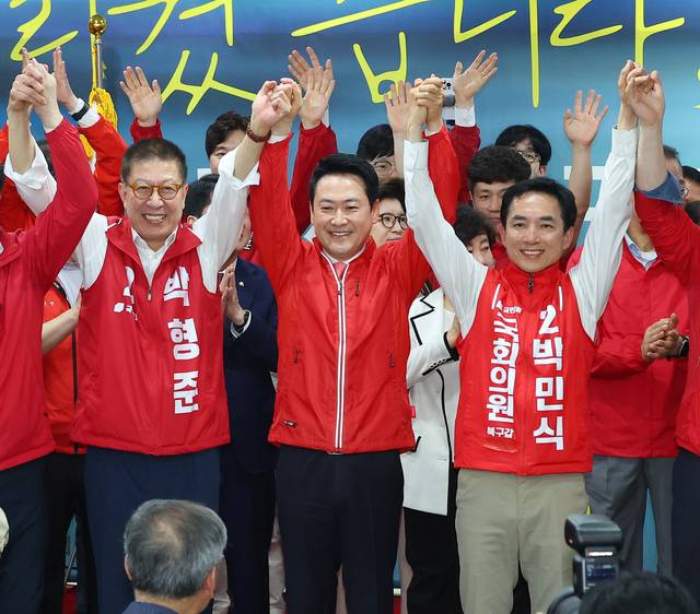 장동혁(가운데) 국민의힘 당대표가 지난 5월 10일 오후 부산 북구에서 열린 박민식(오른쪽) 북갑 국회의원 보궐선거 후보 선거사무소 개소식에서 박민식 후보 및 박형준(왼쪽) 부산시장 후보 등과 손을 맞잡고 있다. [연합뉴스]