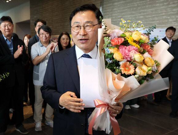 정근식 서울시교육감 당선인이 4일 서울시교육청으로 출근하며 직원에게 꽃다발을 받고 있다. 연합뉴스