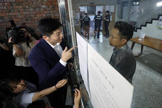 3일 투표용지 부족으로 투표 시간이 오후 10시까지 연장된 서울 송파구 잠실7동 제2투표소를 찾은 김재섭 국민의힘 의원이 선관위 관계자와 닫힌 문을 사이에 두고 대화하고 있다. 뉴스1