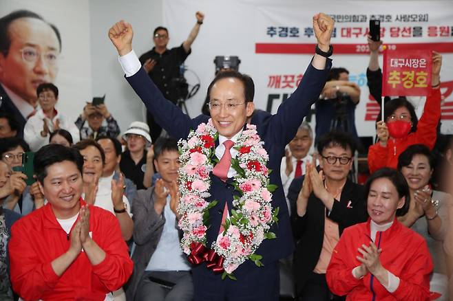 국민의힘 추경호 대구시장 당선자가 4일 오전 대구 범어네거리 선거사무소에서 당선 축하 꽃다발을 목에 걸고 인사하고 있다. 연합뉴스