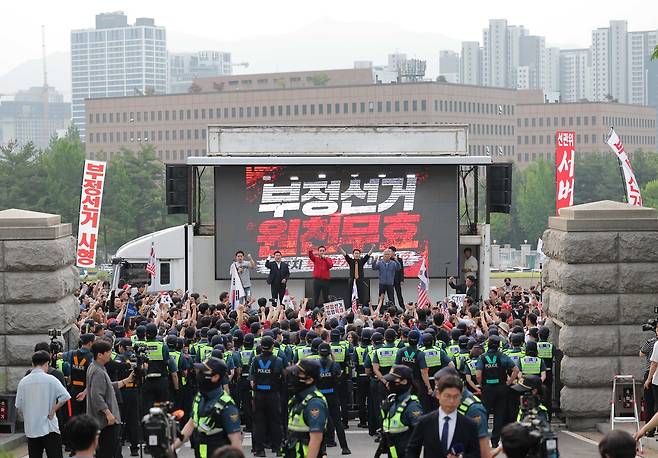 4일 오전 경기 과천 중앙선거관리위원회 앞에서 열린 지선 투표용지 부족 사태 항의 집회 현장. 경찰 기동대가 선관위 정문을 가로막고 있다. [연합]