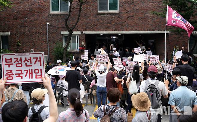 [서울=뉴시스] 홍효식 기자 = 4일 6·3 지방선거 투표용지 부족 사태를 겪은 서울 송파구 잠실7동 제2투표소 앞에서 시민들이 '선거관리위원회 해체, 부정선거, 재선거' 구호를 외치고 있다. 2026.06.04. yesphoto@newsis.com