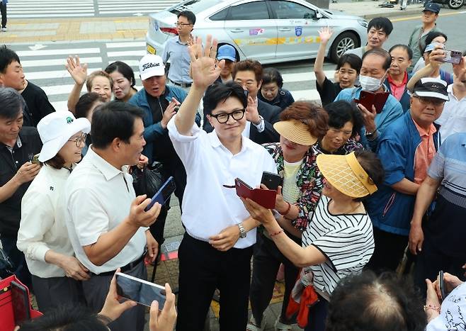 부산 북구갑 보궐선거에 무소속으로 출마해 승리한 한동훈 당선인이 4일 부산 북구 구포시장에서 시민들에게 둘러싸인 채 손을 흔들며 감사 인사를 하고 있다. 부산 연합뉴스