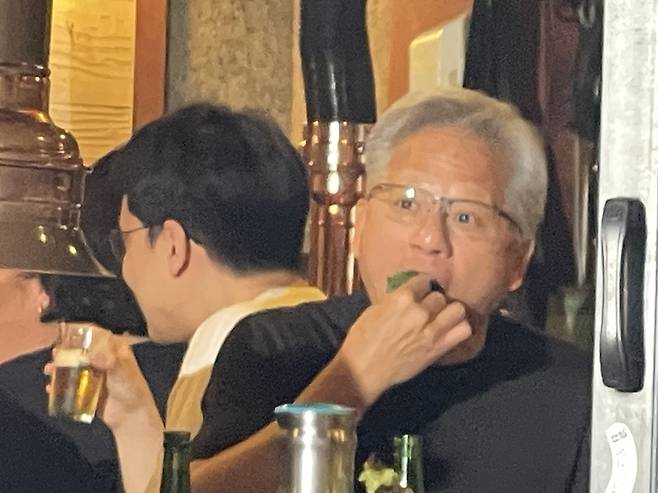 ▲젠슨 황 엔비디아 최고경영자(CEO)가 5일 서울 마포구 홍대입구역 인근 식당에서 열린 만찬에서 직접 고기 쌈을 싸 먹고 있다. 사진=박지성 기자