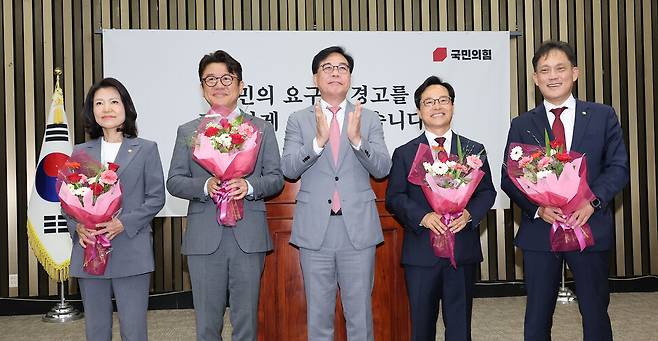 국민의힘 송언석 원내대표와 6·3 재보궐선거에서 당선된 의원들이 5일 국회에서 열린 의원총회에서 두 손을 맞잡고 기념 촬영을 하고 있다. 왼쪽부터 대구 달성 이진숙 의원, 경기 평택을 유의동 의원, 송 원내대표, 충남 공주·부여·청양 윤용근 의원, 울산 남갑 김태규 의원. 연합뉴스