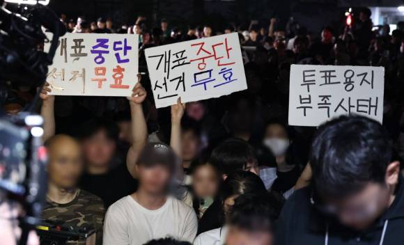 4일 제9회 전국동시지방선거 및 국회의원 재·보궐선거 투표용지 부족으로 투표 시간이 오후 10시까지 연장됐던 서울 송파구 잠실7동 제2투표소 앞에서 ‘부정선거’ 등 손팻말을 든 보수 성향 시민 등이 구호를 외치고 있다. [사진=연합뉴스]