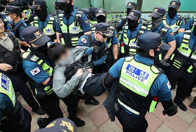 5일 서울 송파구 잠실7동 2투표소 앞에서 경찰이 투표함 이송을 위해 이를 막아선 시위대를 해산 조치하고 있다.  [연합]