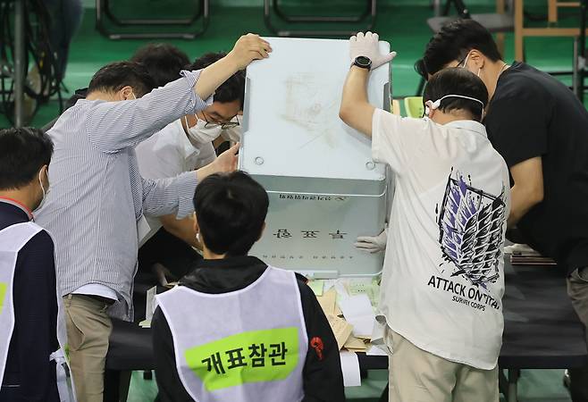 5일 서울 송파구 잠실7동 제2투표소에서 이송된 투표함이 개표소인 올림픽공원 핸드볼경기장에 도착해 참관인이 지켜보는 가운데 투표함을 열고 있다. [연합]