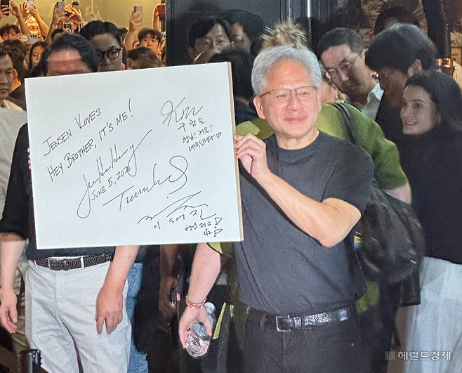 젠슨 황 엔비디아 최고경영자(CEO가 5일 서울 마포구 홍익대학교 인근 삼겹살 음식점 ‘형님 저요’에서 최태원 SK그룹 회장, 구광모 LG그룹 회장, 이해진 네이버 의장과 함께 남긴 서명을 들어보이고 있다. 이정완 기자