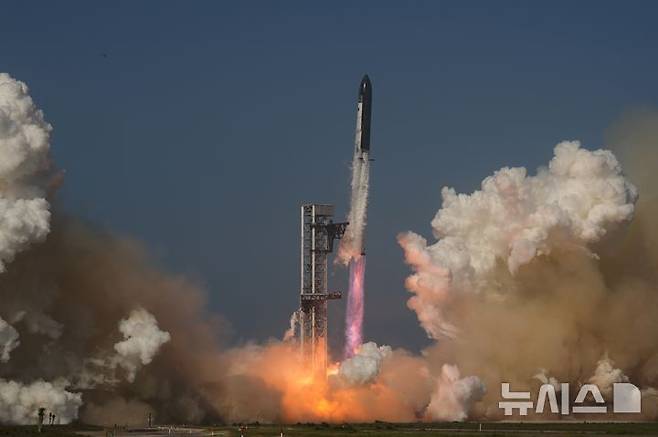 [스타베이스=AP/뉴시스] 일론 머스크의 전기차 기업 테슬라와 항공우주 기업 스페이스X가 하나로 합칠 수 있다는 주장이 제기됐다. 미국 경제매체 CNBC는 26일(현지시간) 내부 사정에 정통한 관계자들의 말을 인용해 "머스크 CEO가 스페이스X와 테슬라를 하나로 묶는 방안을 측근들과 논의해 왔다"고 보도했다. 사진은 스페이스X의 스타십 로켓이 2026년 5월22일(현지시각) 미국 텍사스주 스타베이스에서 시험비행을 위해 발사되고 있는 모습. 2026.05.27.