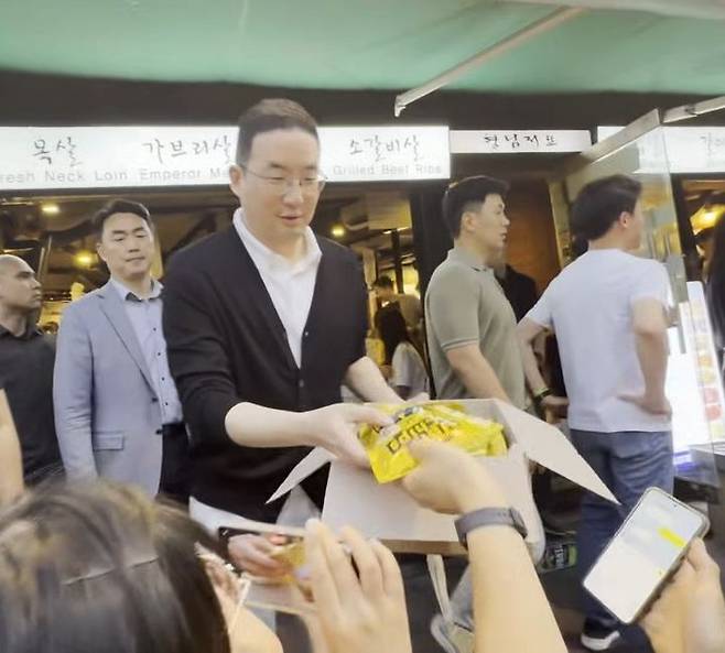 [서울=뉴시스] 구광모 LG그룹 회장이 5일 서울 마포구 한 식당 앞에서 SK하이닉스가 만든 반도체 콘셉츠 과자 '허니바나나맛 HBM 칩스'를 관중들에게 나눠주고 있다. 2026.06.05 photo@newsis.com *재판매 및 DB 금지