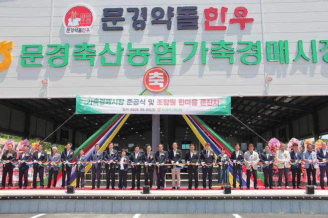 문경축산농협 가축경매시장 준공식에 참석한 인사들이 기념 테이프를 자르고 있다.