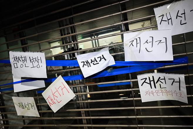 6일 새벽 서울 송파구 올림픽공원 핸드볼경기장 출입구에 재선거 문구가 적힌 종이가 붙어있다. / 고운호 기자