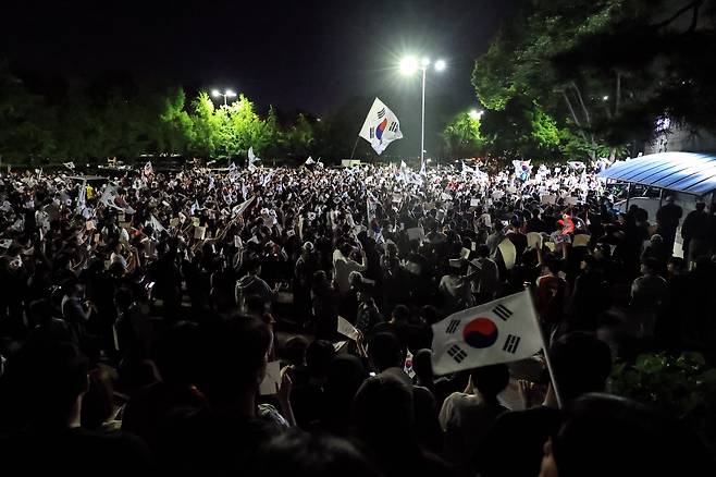 6일 새벽 서울 송파구 올림픽공원 핸드볼경기장 앞에서 시민들이 태극기와 ‘재선거’라고 적힌 손팻말을 들고 선거 관리 부실에 항의하고 있다. 이들은 투표용지 부족 사태와 개표 과정에 대한 문제 제기를 하며 경기장 주변에 모였다. / 고운호 기자
