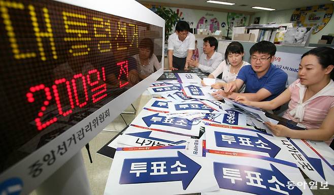〈대선 200일 앞〉 투표소 용품 디자인도 멋지게. 경기 과천시 중앙선거관리위원회 선거상황팀 직원들이 새 투표소 사무용품 디자인을 점검·토의하고 있다. (동아일보, 2007년 6월 1일, 이훈구 기자)