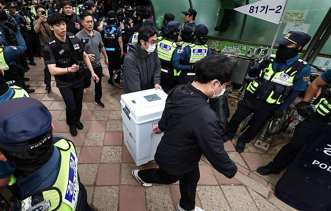 5일 투표용지 부족 사태가 발생한 서울 송파구 잠실7동 제2투표소 앞에서 서울시선관위 관계자들이 투표함을 이송하고 있다. 뉴스1