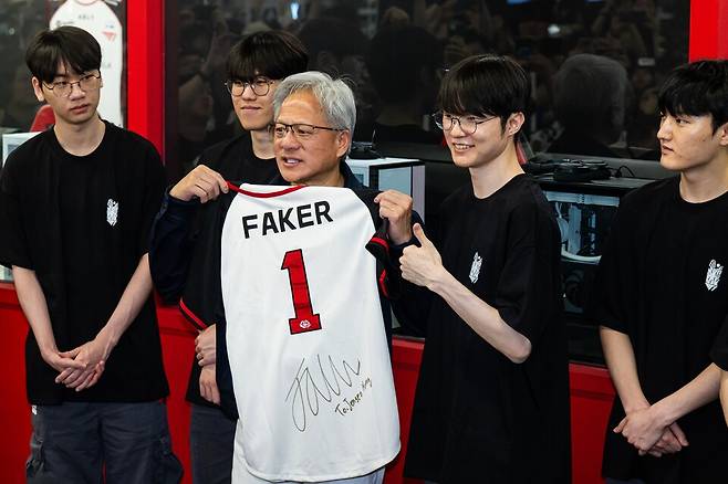 젠슨 황 엔비디아 최고경영자(CEO)가 5일 서울 마포구 T1베이스 캠프에서 '페이커' 이상혁을 비롯한 e스포츠 구단 T1의 리그 오브 레전드(LoL) 선수단을 만나 페이커의 사인이 담긴 기념품을 선물 받고 있다. ⓒ연합뉴스