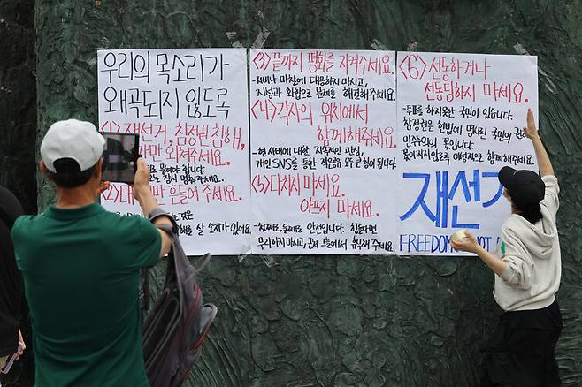 6·3지방선거 재선거와 부정선거를 주장하는 시위대가 7일 오전 잠실7동제2투표소 투표함 개표가 뒤늦게 진행된 서울 송파구 올림픽공원 핸드볼경기장 조형물에 시위대가 대자보를 붙이고 있다. 김혜윤 기자 unique@hani.co.kr