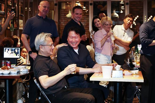 젠슨 황 엔비디아 최고경영자(CEO)와 최태원 SK 회장이 7일 서울 강남구 깐부치킨 삼성점에서 치맥 회동을 하던 중 대화를 나누고 있다. 연합뉴스