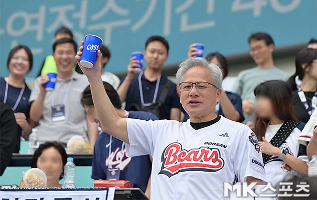 7일 서울 잠실야구장에서 ‘2026 프로야구’ 키움 히어로즈와 두산 베어스의 경기가 열렸다. 이날 시구는 엔비디아 최고경영자(CEO) 젠슨황이 나섰다. 젠슨황은 엔비디아 창립 연도인 1993년을 뜻하는 ‘93 ’번 유니폼을 입고 시구를 진행했다. 박정원 두산그룹 회장은 두산 창립 연도(1896년)를 의미하는 ‘96’ 번 유니폼을 입고 시타자로 나서 투타 호흡을 맞췄다. 젠슨황이 관중석에서 건배를 하고 있다. 사진(잠실 서울)=천정환 기자