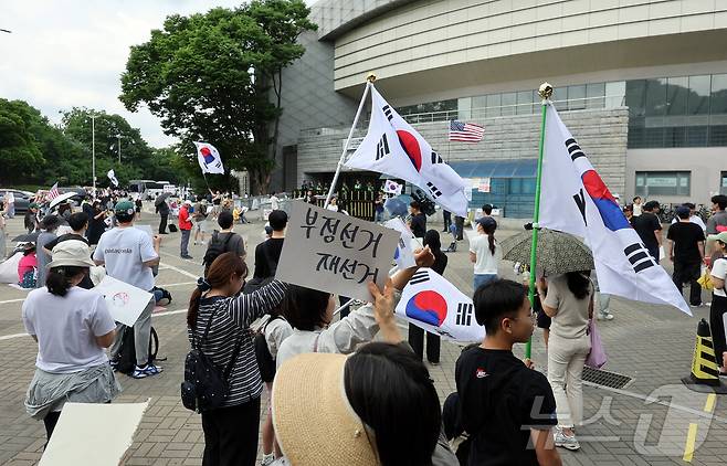 제9회 전국동시지방선거 투표용지 부족 사태에 반발한 시민들이 8일 서울 송파구 올림픽공원 핸드볼경기장 개표소 앞에 모여 재선거를 요구하는 구호를 외치고 있다. 2026.6.8 ⓒ 뉴스1 김진환 기자