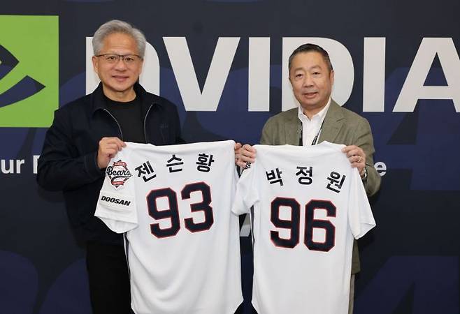 박정원 두산그룹 회장과 젠슨 황 엔비디아 최고경영자가 7일 잠실야구장에서 유니폼을 교환하고 있다. 두산그룹
