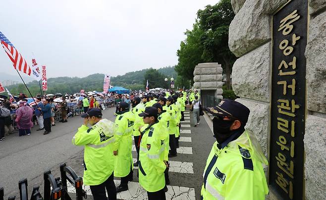 4일 경기 과천시 중앙선거관리위원회 과천청사 앞에서 투표용지 부족 사태 관련 항의 집회가 이어지는 가운데 경찰이 청사 내에서 경계 근무를 서고 있다. 뉴시스