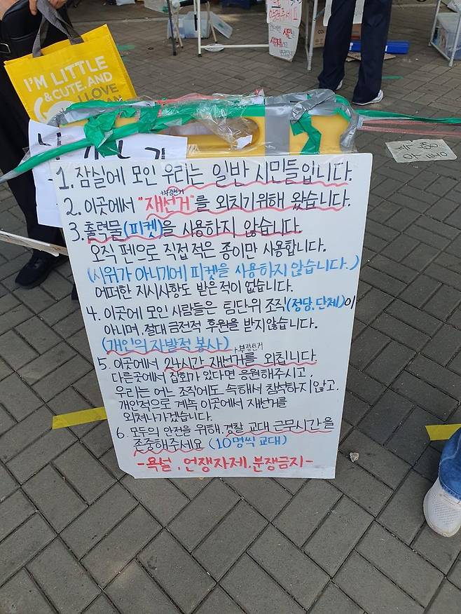 집회 참가자들이 현장 질서 유지를 위해 작성한 안내문을 세워두고 있다. 사진=최승한 기자