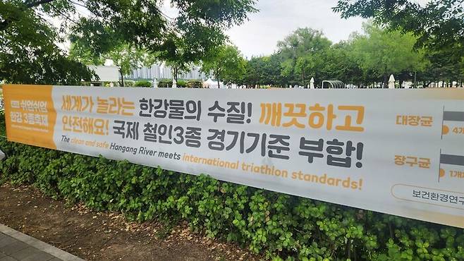 한강물의 수질 기준이 국제 철인3종 경기 기준에 부합하다는 판정이 나왔다는 사실을 알리는 펼침막.