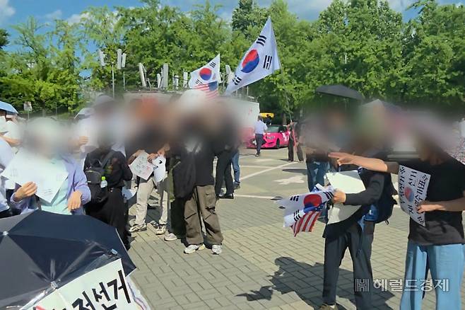 8일 오후 4시께 서울 송파구 올림픽공원에서 이어지고 있는 투표용지 부족 사태 반발 집회에서 참가자들이 성조기 사용 여부를 놓고 다투고 있다. 이영기 기자