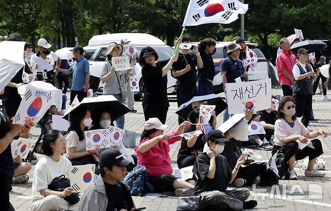 [서울=뉴시스] 김혜진 기자 = 제9회 전국동시지방선거 투표용지 부족 사태에 항의하며 개표소 봉쇄 시위를 이어가는 시민들이 8일 서울 송파구 올림픽공원 핸드볼경기장에 설치된 개표소 앞에서 재선거를 요구하고 있다. 2026.06.08. jini@newsis.com