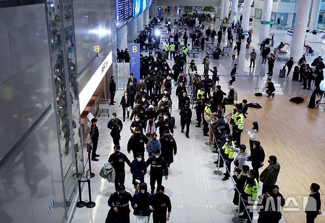 [인천공항=뉴시스] 김진아 기자 = 한국 국적 캄보디아 스캠조직 피의자들이 23일 오전 인천국제공항 제2터미널을 통해 강제 송환되고 있다.  초국가범죄 특별대응 TF는 캄보디아를 거점으로 우리 국민 869명에게 약 486억원을 편취한 한국 국적 피의자 73명을 강제 송환했다. 2026.01.23. bluesoda@newsis.com