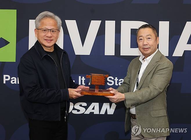 기념품 전달하는 박정원 회장 (서울=연합뉴스) 박정원 두산그룹 회장(오른쪽)이 7일 서울 잠실야구장을 방문한 젠슨 황 엔비디아 CEO에게 두산을 상징하는 조형물인 두산일두를 기념품으로 전달하고 있다. 2026.6.7 [두산그룹 제공. 재판매 및 DB 금지] photo@yna.co.kr