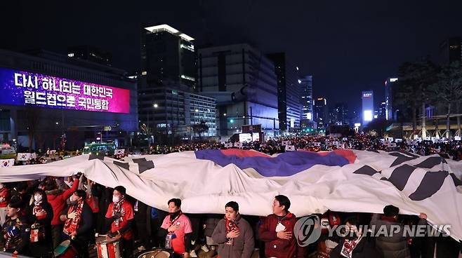 광장의 태극기 (서울=연합뉴스) 황광모 기자 = 2일 밤 서울 종로구 광화문 광장에서 열린 2022 카타르 월드컵 H조 예선 한국과 포르투갈 경기 합동 응원에 나선 붉은악마와 시민들이 대형 태극기를  펼치며 응원을 펼치고 있다. 2022.12.2 hkmpooh@yna.co.kr