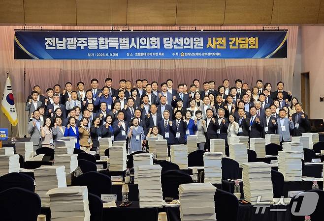 전남광주통합특별시의회 당선인들이 간담회에 앞서 기념사진을 찍고 있다. 당선의원들의 책상에 '통합시의회 사전 보고'자료가 높이 쌓여 있다. 2026.6.9. 뉴스1 ⓒ News1 조영석 기자