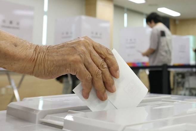 제9회 전국동시지방선거 사전투표 첫날인 29일 세종시 북세종통합행정복지센터에 마련된 투표소에서 한 시민이 투표함에 기표를 마친 투표용지를 넣고 있다. 연합뉴스