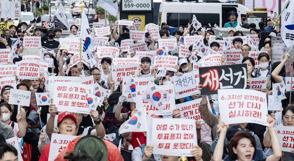 지난 7일 부산 부산진구 하트조형물 앞 광장에서 부산 자유민주주의연합, 브라이트 자유청년 연대 및 시민들이 6.3 지방선거 원천무효 집회를 열고 “재선거”를 외치고 있다. 이원준 기자