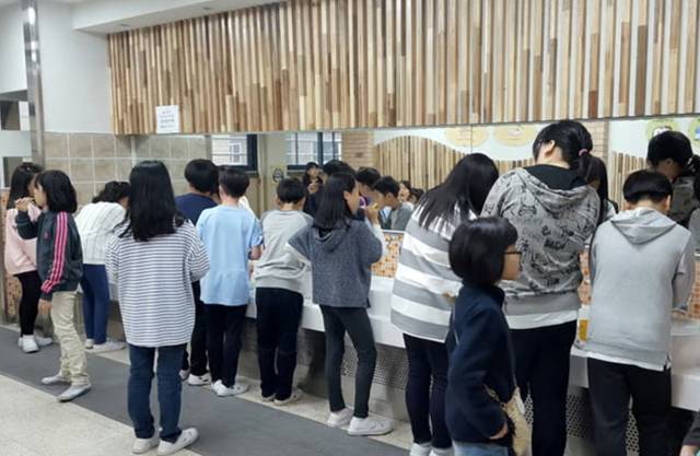 서울의 한 초등학교에 마련된 양치 전용 시설에서 학생들이 점심 식사 후 양치를 하고 있다. 뉴시스