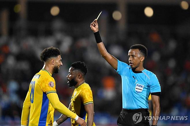 옐로 카드를 꺼내는 오마르 아르탄 심판 [AFP=연합뉴스 자료사진]