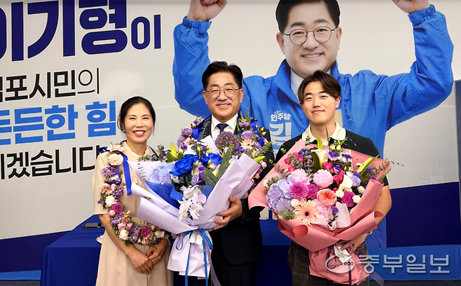 더불어민주당 김포시장으로 당선된 이기형 후보가 지지자들의 건네준 꽃다발을 들과 가족과 함께 기념 사진을 찍고 있다. 천용남 기자