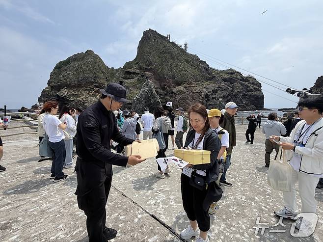 독도경비대에 학생 편지들을 전달하고 있는 부천수주초등학교 정수경 교사.(동북아역사재단 제공)