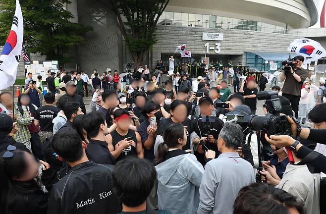 6·3 지방선거 투표용지 부족 사태를 규탄하는 개표소 봉쇄 시위가 이어진 10일 서울 송파구 올림픽공원 핸드볼경기장 앞에서 시위대가 체육 단체 직원들의 출입 허용 여부와 관련해 의견을 나누고 있다. 연합뉴스