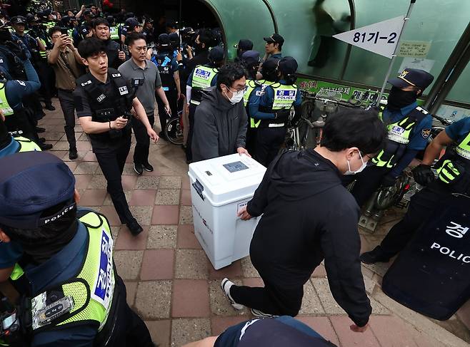투표용지 부족 사태가 발생한 서울 송파구 잠실7동 제2투표소 앞에서 5일 서울시선관위 관계자들이 투표함을 이송하고 있다. 뉴스1