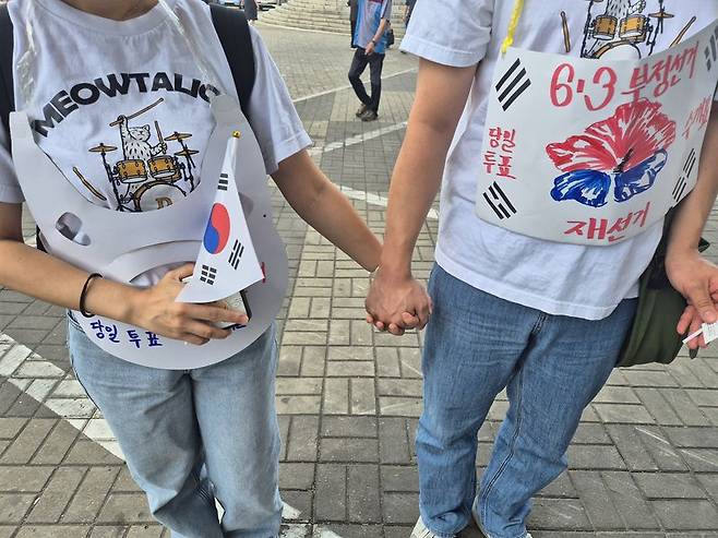 평일 참가자가 많이 모이지 않을 시간대에 힘을 보태기 위해 연인 손을 잡고 집회 현장을 찾은 장성훈씨와 고은하씨. 사진=김예지 기자