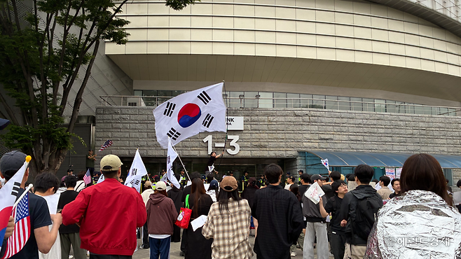 지난 8일 오전 6시40분께 서울 송파구 올림픽공원 핸드볼경기장 앞 재선거를 요구하는 시위 참가자들이 태극기를 흔들고 있다. 김서현 수습기자