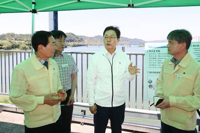 박완수 경남도지사(가운데)가 칠서취수장에서 녹조 대응 및 안전한 수돗물 공급 상황을 살피고 성낙인 창녕군수(가장 왼쪽) 등 관계자들과 대화하고 있다. [사진제공=경남도]
