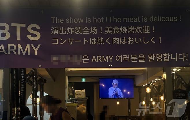 방탄소년단(BTS)의 'BTS 월드투어 아리랑 IN 부산' 공연 둘째 날인 13일 부산 아시아드주경기장 인근 식당에서 BTS와 아미(BTS 팬덤)들을 환영한다는 현수막을 내걸었다. 식당 내부 TV에는 BTS의 영상이 재생되고 있다. 2026.6.14 ⓒ 뉴스1 박서현 기자